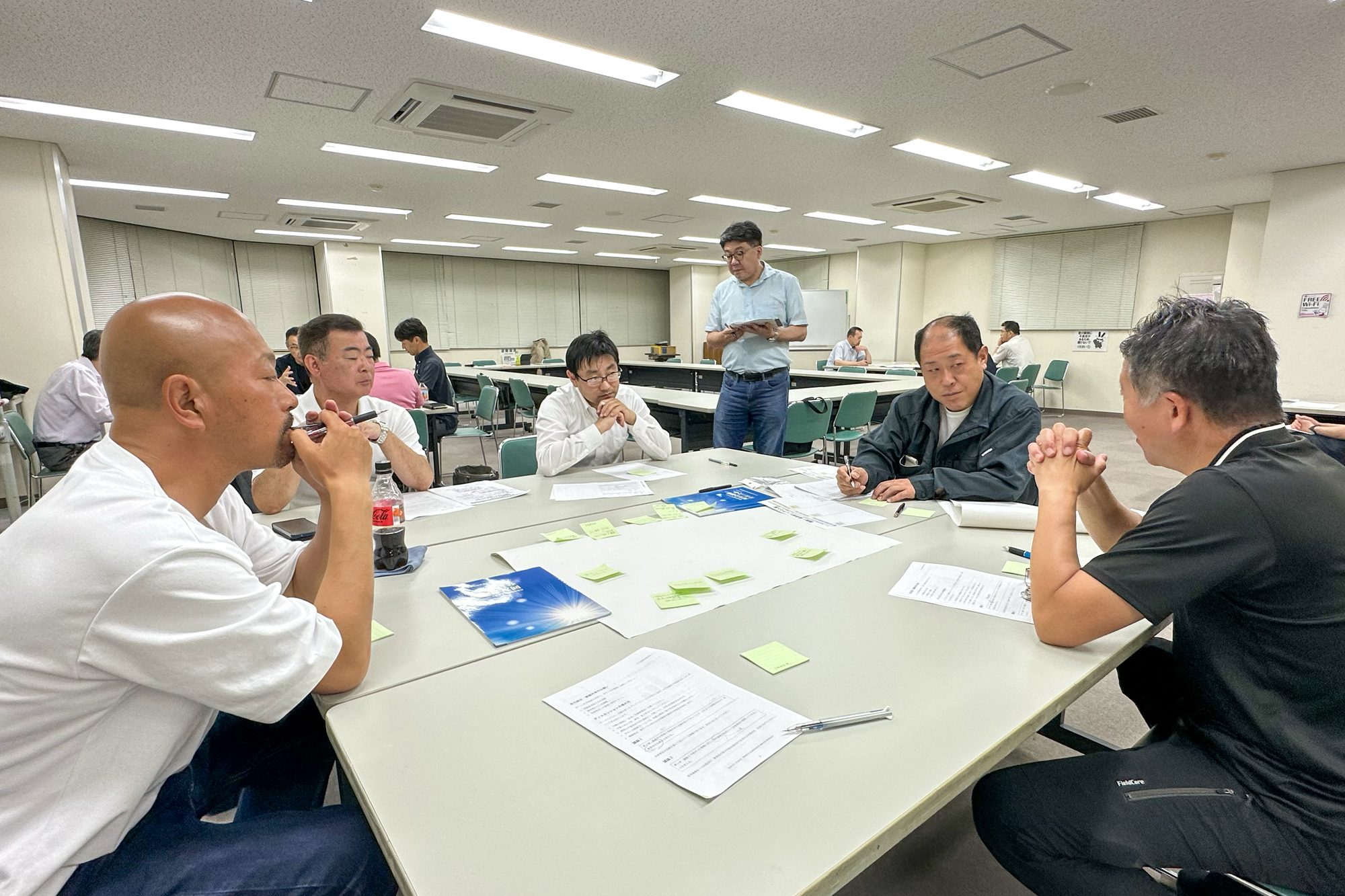 委員会で机を囲み、付箋を使って討議する会員の様子