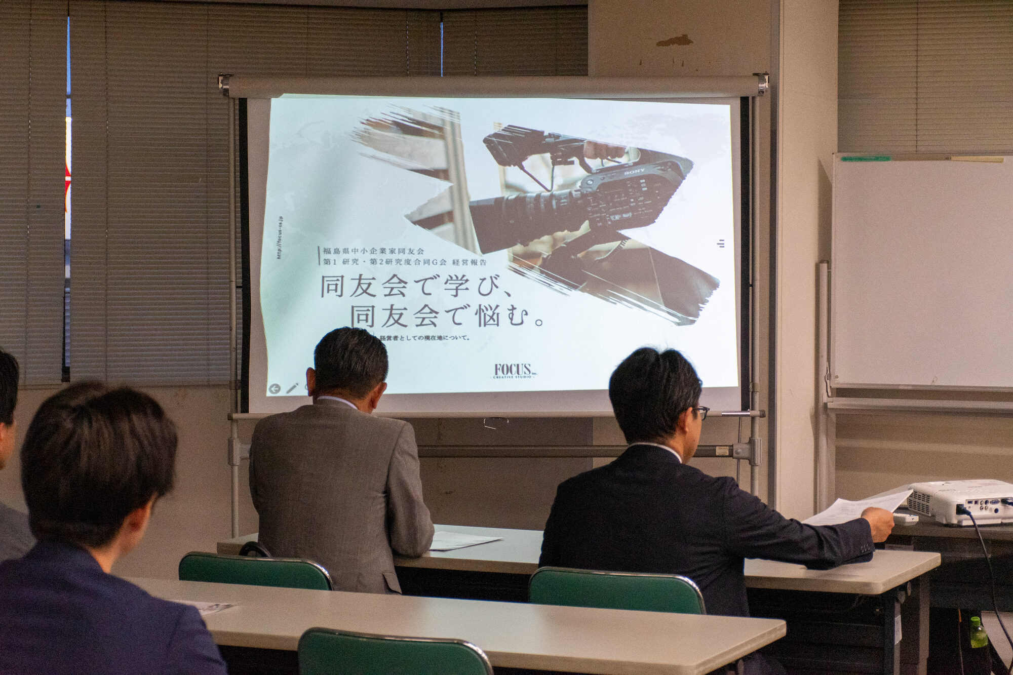 合同グループ会で「同友会で学び、同友会で悩む。」と投影されたスクリーンに見入る会員の様子